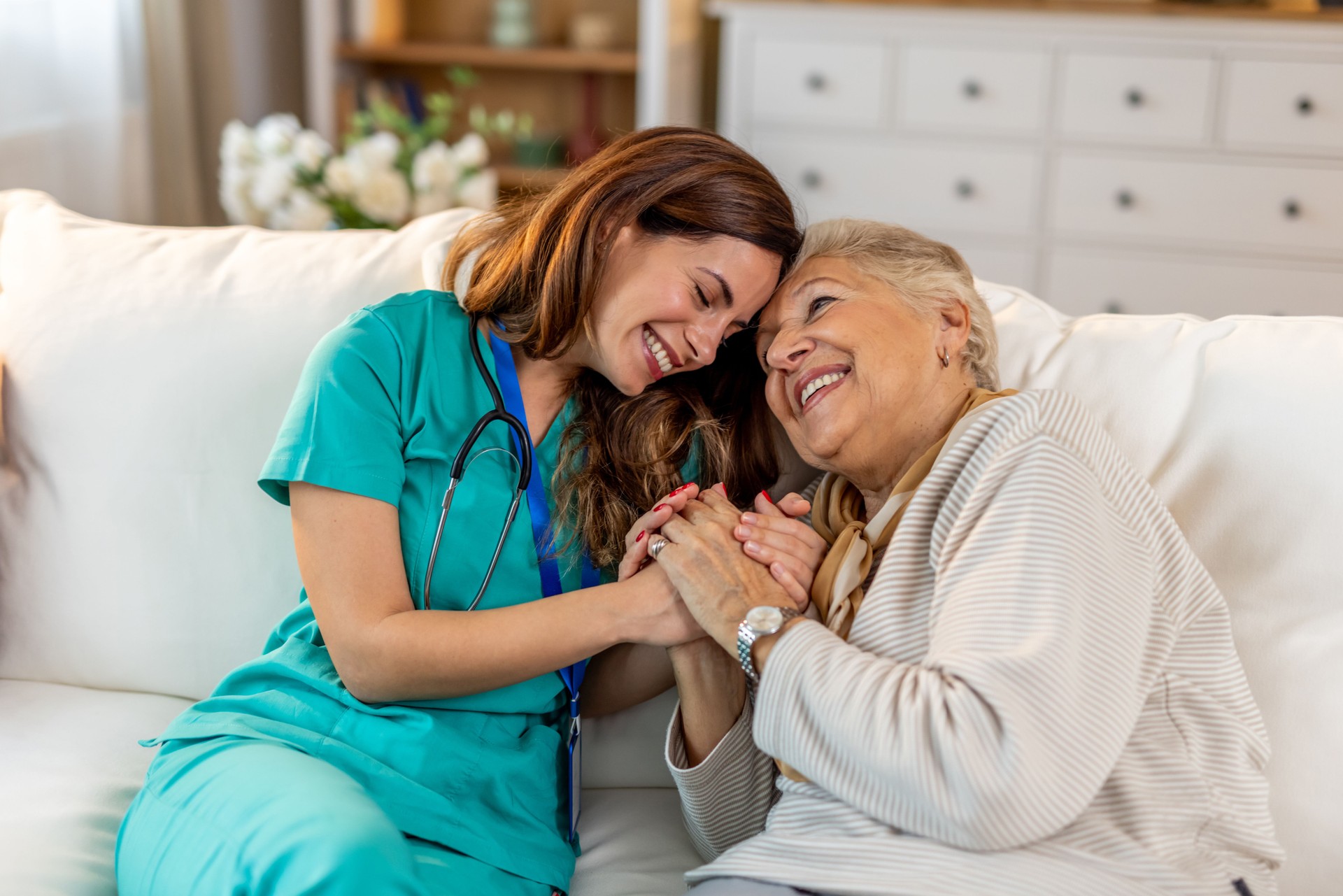 Nurse Comforting Elderly Woman on a Sofa with Warm Smiles and Caring Gestures