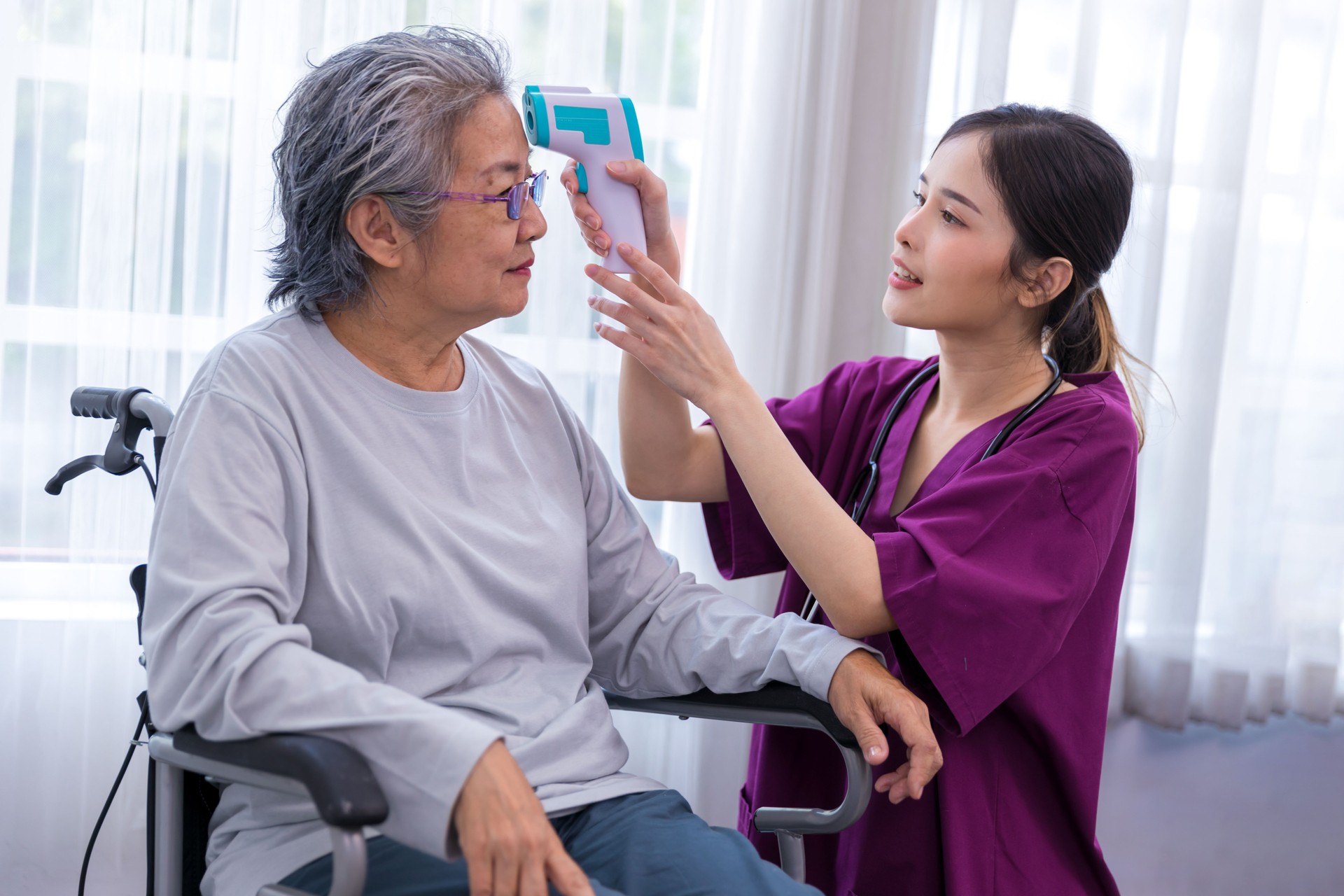 Caregiver nurse take care a Senior patient walking in park. Nurse helping senior Woman