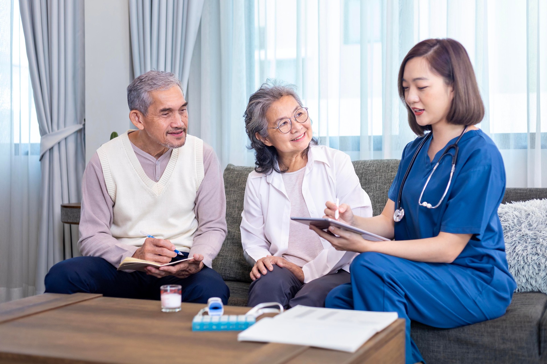 Senior couple get medical service visit from caregiver nurse at home while having result of medical exam for health care and pension welfare insurance
